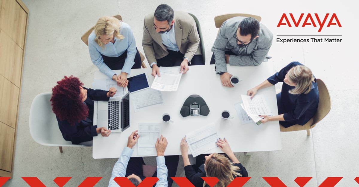 Work colleagues at a table witih an Avaya B109 conference phone