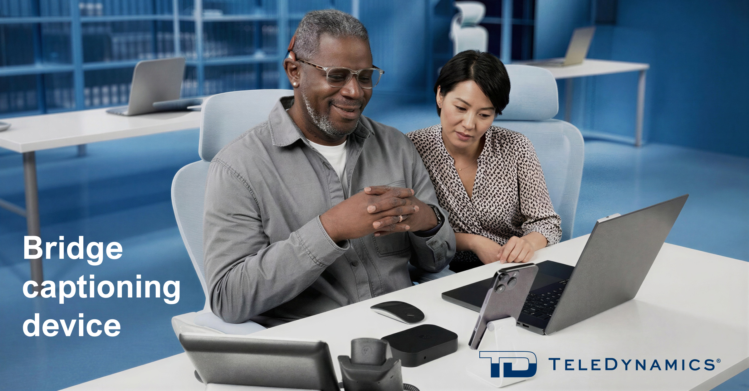 Colleagues on a call using a Bridge captioning device – distributed by TeleDynamics