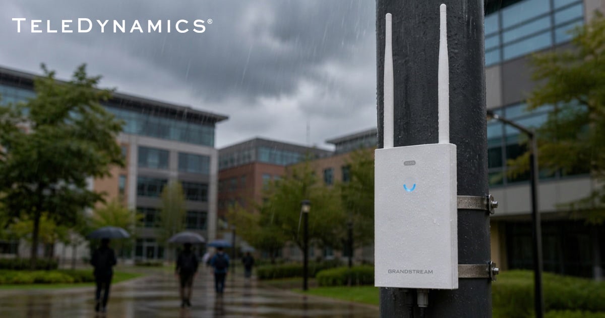 Grandstream GWN7660LR outdoor wireless access point on a modern business campus, on a rainy day - TeleDynamics blog