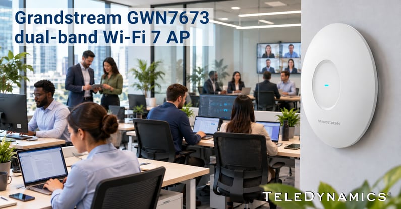 Grandstream GWN7673 Wi-Fi 7 wireless access point mounted on an office wall, supporting a busy workplace with multiple connected devices -- distributed by TeleDynamics