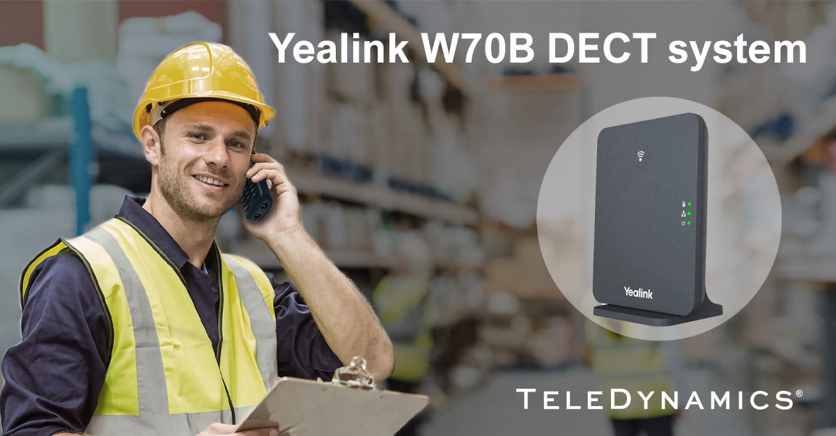Worker in a warehouse speaking on a Yealink DECT handset with a W70B base station - distributed by TeleDynamics