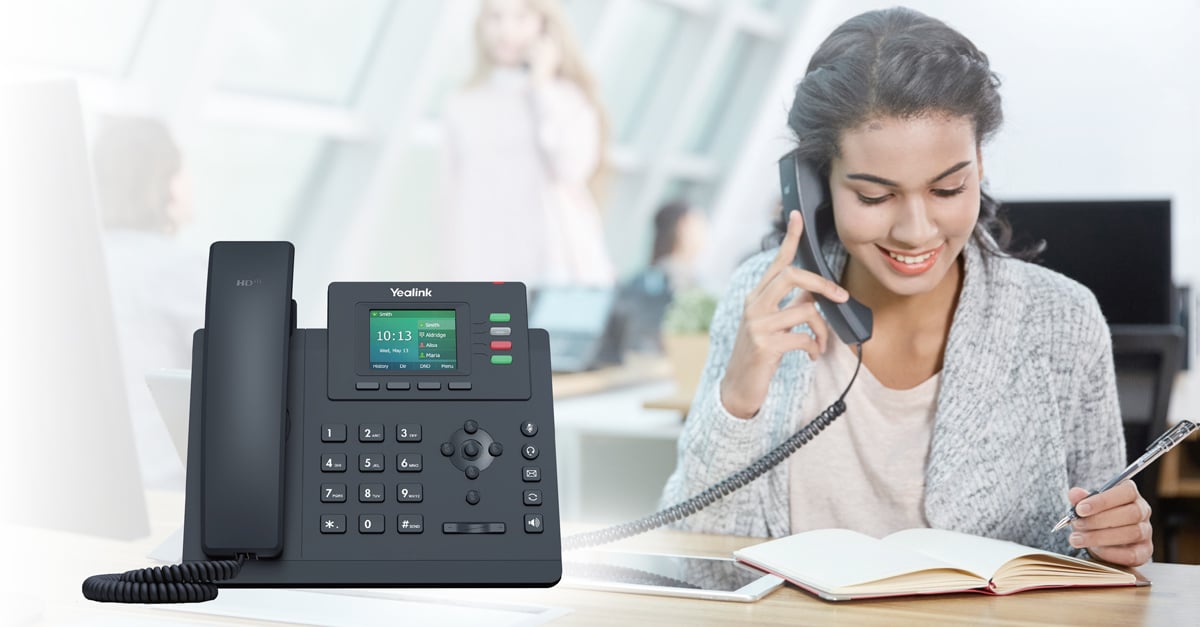 Woman talking on a Yealink T33 IP phone