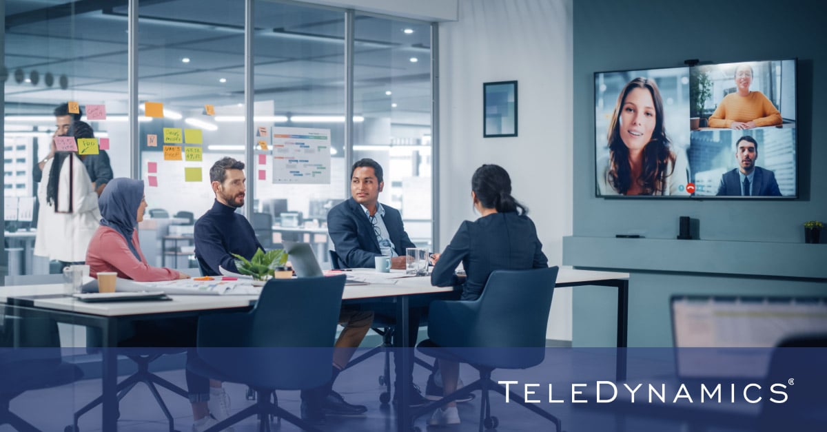 colleagues around a conference table using Yealink Android meeting solutions, distributed by TeleDynamics