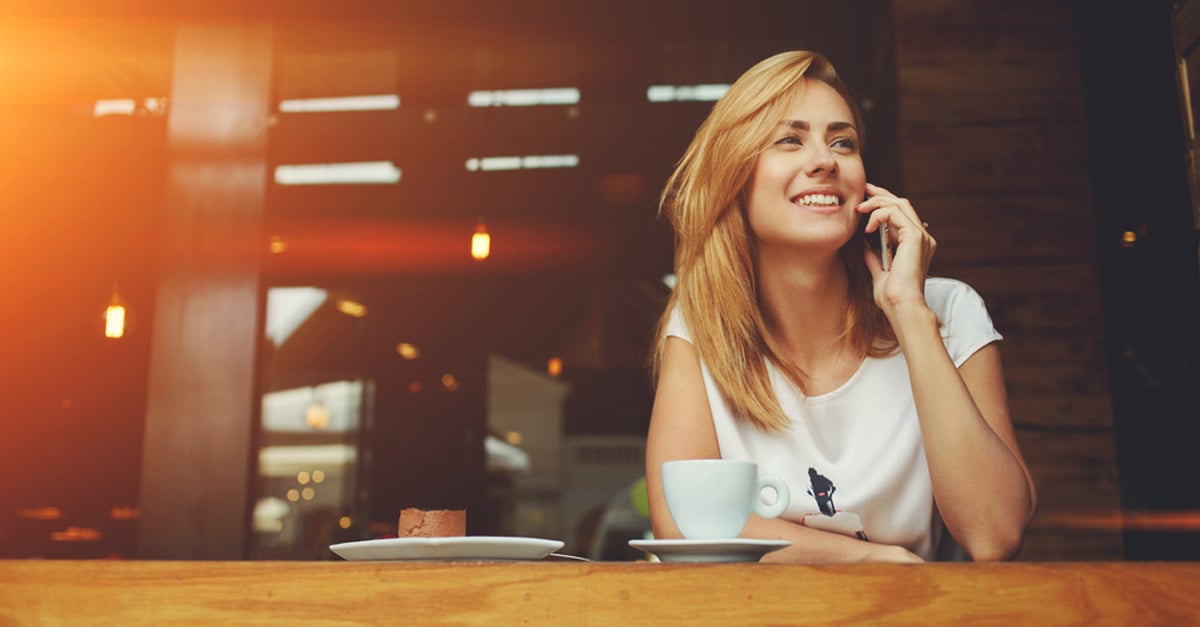 smiling woman waiting on the phone