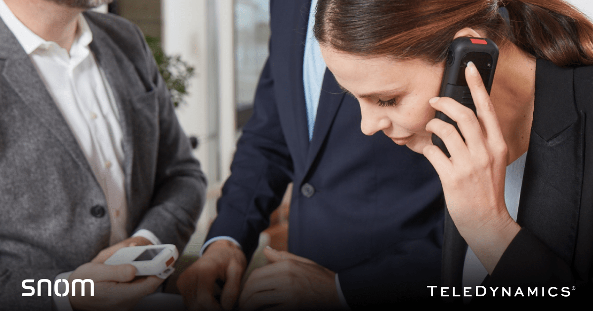 Woman speaking on a Snom phone in office environment - TeleDynamics blog 