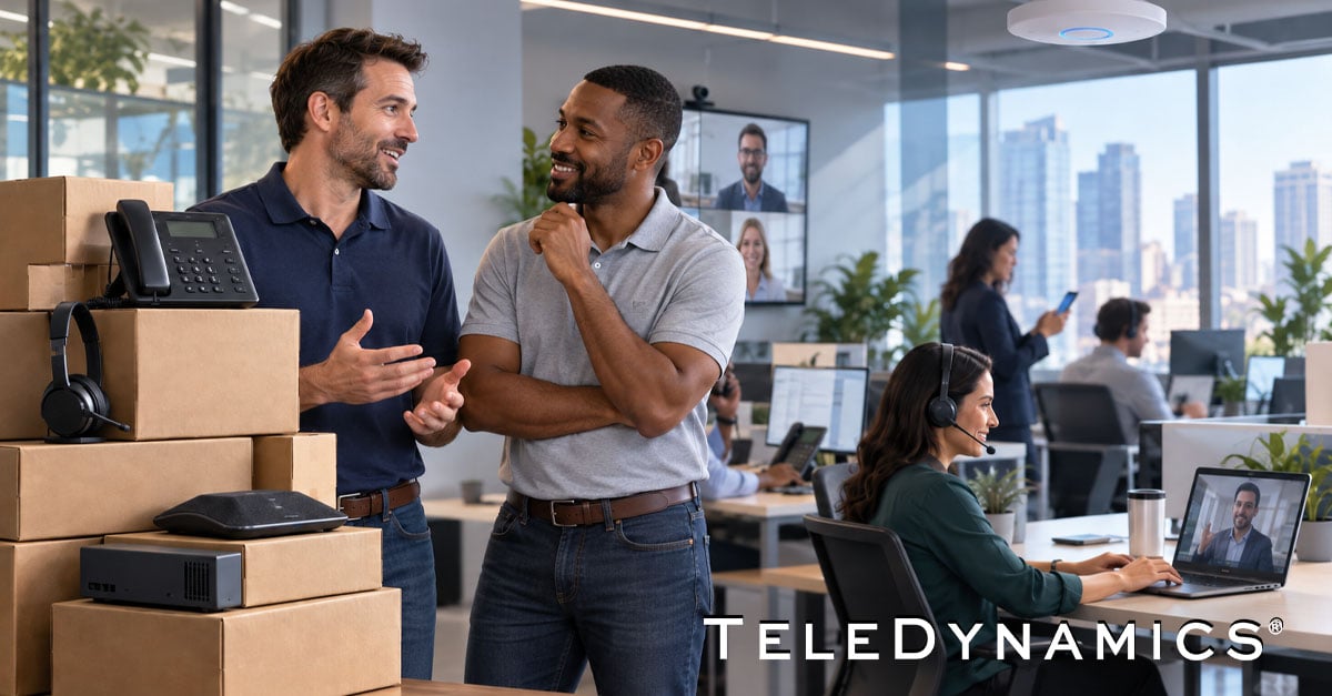 Two UC resellers discuss telecom solutions beside stacked equipment boxes, with employees using phones, headsets, and video conferencing in a modern office -- TeleDynamics blog