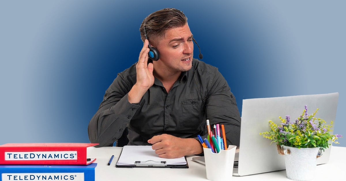Worker at his desk listening through a monaural headset - TeleDynamics blog