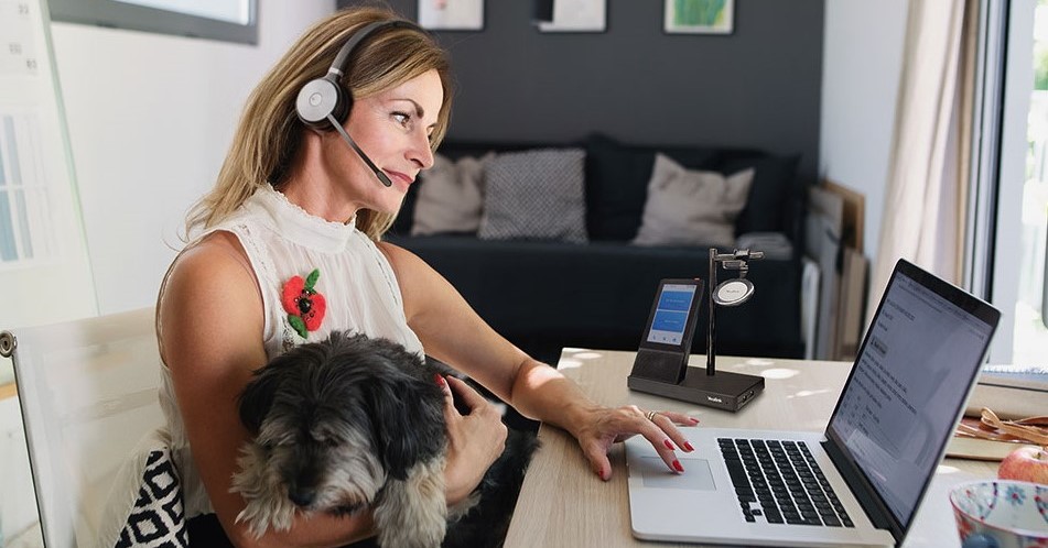 Woman working from home with Yealink headset - TeleDynamics blog